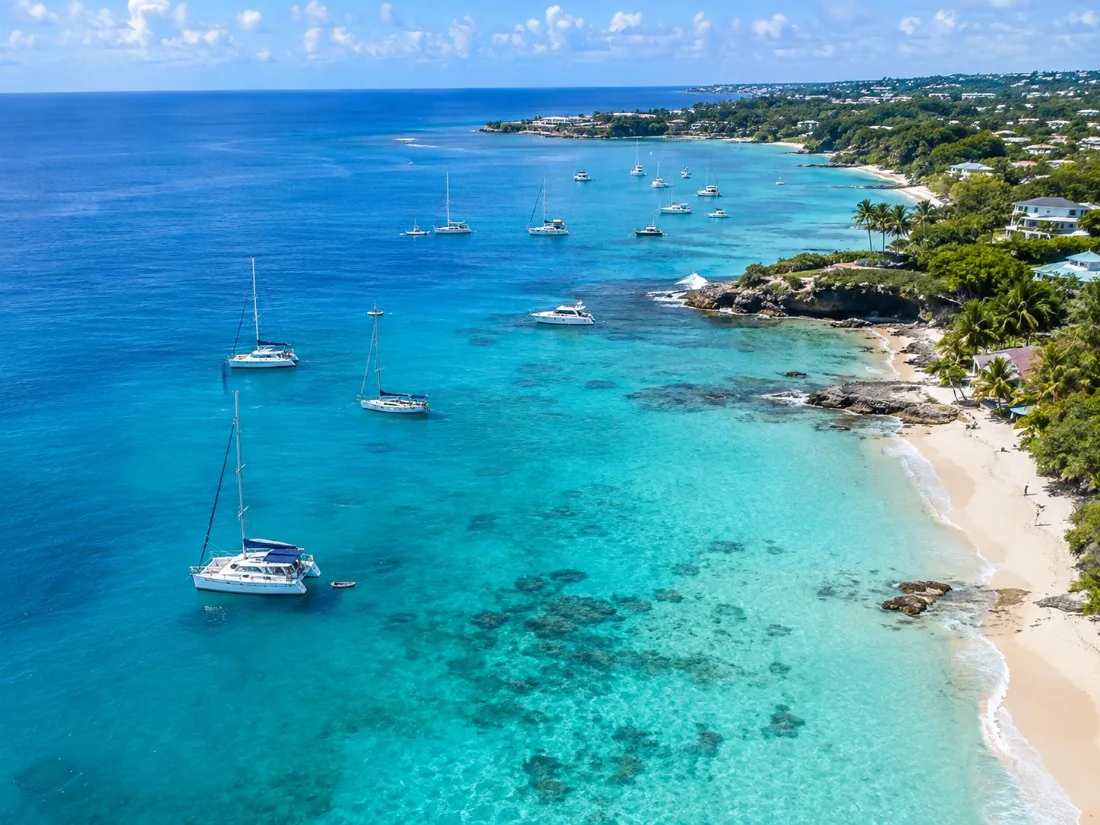 Aerial view of the calm west coast of Barbados with boats at anchor over turquoise and blue water